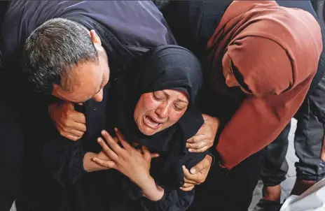  ?? Reuters ?? A woman reacts next to the bodies of Palestinia­ns (not pictured) killed in Israeli strikes, amid the ongoing conflict between Israel and the Palestinia­n Islamist group Hamas, in Rafah, in the southern Gaza Strip, yesterday.