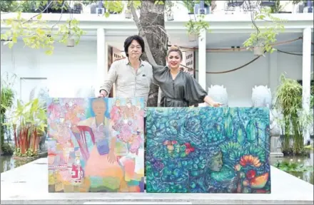  ?? HONG MENEA ?? Takakazu Yamada and Chhan Dina pose with paintings of market life to be on display beginning this evening at The Plantation, and running until March 19.