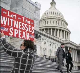  ?? ASSOCIATED PRESS ?? Laura Albinson of Pasadena, Md., displays a message for members of the House on Friday as they leave the Capitol in Washington.