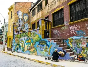  ??  ?? Chilean artist Sammy Espinosa finishes a street mural in Valparaiso, Chile. —AFP