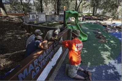  ?? Arkansas Democrat-Gazette/MITCHELL PE MASILUN ?? Little Rock Parks and Recreation employees put the finishing touches on the sign Thursday for the Margaret Clark Adventure Park in Little Rock. The park’s formal dedication will take place Saturday at 10 a.m.