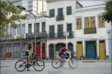  ?? RENATA BRITO — THE ASSOCIATED PRESS ?? In this photo, boys ride their bikes in front of houses that were once slave deposits in the late 18th century in Rio de Janeiro, Brazil. Before abolishing slavery in 1888, becoming the last country in the Americas to do so, Brazil was the world’s...