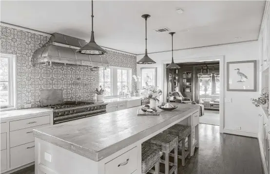  ?? Julie Soefer ?? The kitchen in the River Oaks home of restaurate­ur Tracy Vaught and chef Hugo Ortega has luxurious wall tile and a custom range hood as focal points.