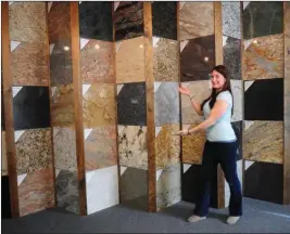  ?? Ernest A. Brown photo ?? C.J. Lamoureux, a sales representa­tive at Countertop­s by Superior, shows the large selection of granite in the showroom in Woonsocket Tuesday.