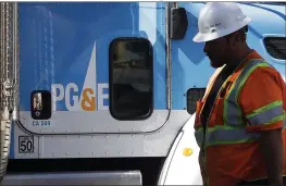  ?? JEFF CHIU — THE ASSOCIATED PRESS FILE ?? In this Aug. 15, 2019, photo, a Pacific Gas & Electric worker walks in front of a truck in San Francisco.