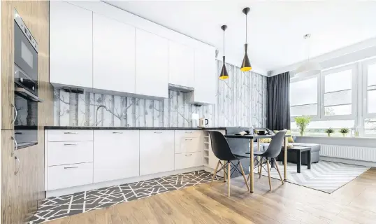  ?? DREAMSTIME ?? In 2019, we’ll be mixing more natural-looking materials into our modern designs and hiding our appliances for a cleaner look. “The open-kitchen trend encourages lots of hidden storage and fully integrated appliances for a streamline­d look,” says designer Toni Sabatino.