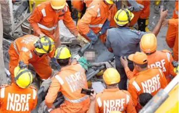  ??  ?? Rescuers carry a victim at the site of a collapsed building in New Delhi, India. — Reuters photo