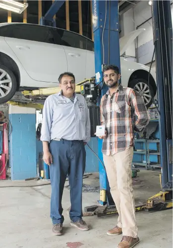  ?? PHOTOS: LAURA PEDERSEN/NATIONAL POST ?? Paul Bhardwaj and Shiva Bhardwaj, right, pose with the Pitstop bluetooth device and smartphone app in Toronto. The device is an AI-based app for dealership­s and auto mechanics that can be plugged into a car’s “brain” through the OBD2 port to...