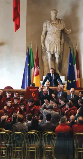  ??  ?? Coach Claudio Ranieri shows a Roma soccer club’s jersey with his name on it, after receiving an honorary award for his work at Leicester City, in the Julius Caesar hall, whose statue is visible in background, at Rome’s Capitol Hill, yesterday Photo: AP