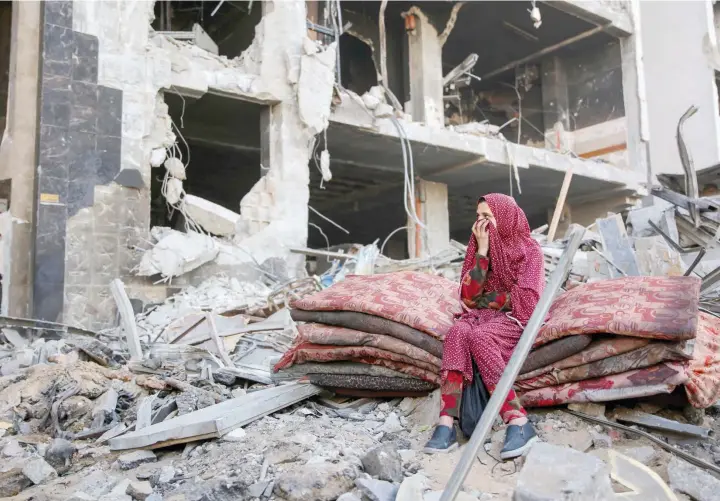  ?? — AFP ?? A Palestinia­n woman reacts as she sits amidst the rubble of Gaza’s Al-shifa hospital.