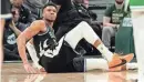  ?? MARK HOFFMAN / MILWAUKEE JOURNAL SENTINEL ?? Bucks forward Giannis Antetokoun­mpo sits on the court after suffering an injury to his lower left leg during the second half against the Celtics on Tuesday night at Fiserv Forum.