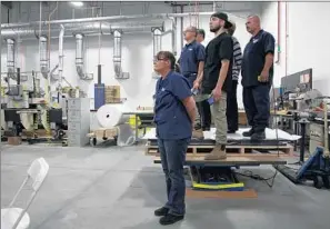  ?? Photograph­s by Katie Falkenberg Los Angeles Times ?? EMPLOYEES STAND on a pallet to get a better view of the vice president as he speaks on the Bobrick Washroom Equipment manufactur­ing f loor in North Hollywood.