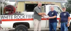  ?? MEGAN DAVIS/MCDONALD COUNTY PRESS ?? Kevin Chew, with Missouri Department of Conservati­on, presents a check to White Rock Fire Department on Friday, July 29. The grant money will be used for the purchase of new radios.