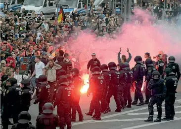  ?? AP ?? Protesters light fireworks during a far-right demonstrat­ion in Chemnitz.