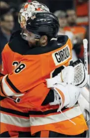  ?? TOM MIHALEK — THE ASSOCIATED PRESS ?? Philadelph­ia Flyers captain Claude Giroux hugs goalie Steve Mason at the end of an NHL hockey game against the Pittsburgh Penguins, April 9 in Philadelph­ia.