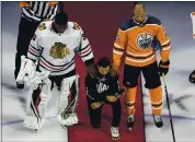  ?? JASON FRANSON — THE ASSOCIATED PRESS ?? Minnesota’s Matt Dumba kneels during the national anthem flanked by Edmonton Oilers’ Darnell Nurse, right, and Chicago Blackhawks’ Malcolm Subban in Edmonton, Alberta.