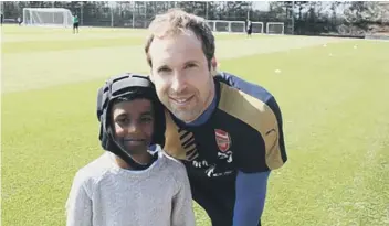  ??  ?? Raihan Ibrahim with one of his heroes, Arsenal’s goal keeper Petr Cech