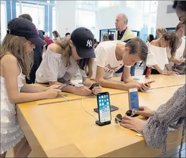  ?? Mark Lennihan Associated Press ?? APPLE IS EXPECTED to reveal three new iterations of the iPhone, the company’s most important product, and other revamped devices this week. Above, shoppers browse at an Apple store last month in New York City.