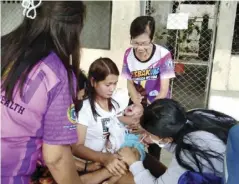  ?? ?? The 76-year-old Margarita Lacerna of Barangay Caigon, Maasin, and a Barangay Health Worker for 46 years, helps the Municipal Health Office and Department of Health personnel during an immunizati­on program.