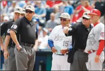  ??  ?? In this May 27, 2013, file photo, Kansas City Royals bench coach Chino Cadahia (15) and St. Louis Cardinals first base coach Chris Maloney (37) exchange line-ups with home plate umpire Rob Drake (30) before a baseball game at Kauffman Stadium in Kansas City, Mo. (AP)