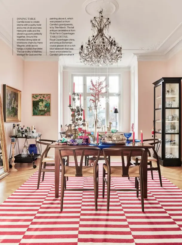  ??  ?? DINING TABLE Camilla loves to create drama with a quirky twist and a mix of old and new. Here pink walls and the vibrant rug work perfectly together. Around the inherited dining table sit Wishbone chairs by Hans Wegner, while above hangs a crystal chandelier. The bar trolley is Mathieu Matégot for Gubi and the painting above it, which was passed on from Camilla’s grandparen­ts, is by Trier Mørch. The tall antique candelabra is from Fil de Fer in Copenhagen
TABLE DETAIL Royal Copenhagen china, and antique Bohemian crystal glasses sit on a rich blue tablecloth that was hand-embroidere­d by Camilla’s grandmothe­r