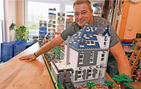  ?? RP-FOTOS (2): JÖRG KNAPPE ?? Claus-Marc Hahn mit seinem Haus aus Lego in seinem Haus in Viersen-Bockert. Gerade hat er neue Regale für den Keller bekommen, deswegen stehen Kisten voller Legosteine in seinem Esszimmer.