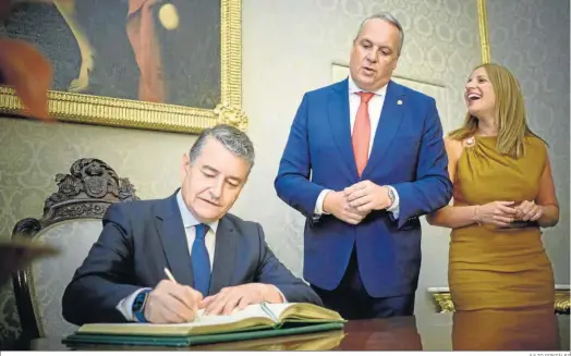  ?? JULIO GONZÁLEZ ?? Antonio Sanz firma en el libro de honor de Diputación tras su primera visita ante la mirada de Juan Carlos Ruiz Boix y la diputada Ana Carrera.