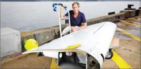  ?? PETER MATHEW/CSIRO/AFP ?? Oceanograp­her David Griffin poses with a Boeing 777 flaperon, used for drift modelling, in Hobart on April 20.