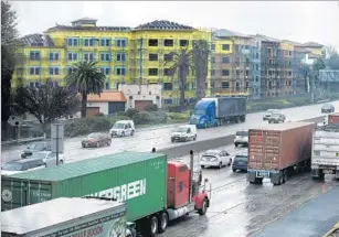  ??  ?? TRAFFIC MOVES past the Sage apartments under constructi­on next to the 91 Freeway in Cerritos. More than 1.2 million people live within 500 feet of a Southern California freeway.