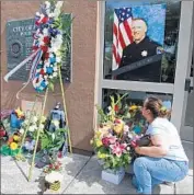  ??  ?? HAYWARD resident Hilda Sierra visits a memorial for Lunger, a 15-year veteran of the police force and father of two daughters, outside the police station.