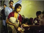  ?? JES AZNAR/GETTY IMAGES ?? Villagers receive food aid in Champasak, Laos, as they take refuge in a makeshift evacuation center Wednesday after they escaped the fast-rising waters from a damaged dam in southeaste­rn Laos.