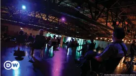  ??  ?? Colored spot lights shine on people waiting to be vaccinated at Berlin's Arena Vaccinatio­n Center