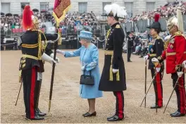  ??  ?? Cérémonie qui honore les régiments de la garde personnell­e de la reine.