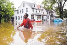  ?? MATT ROURKE/ASSOCIATED PRESS ?? Chris Smith wades through floodwater­s to the Macedonia Baptist Church in Westville, New Jersey, Thursday. Severe storms, heavy rains and strong winds spurred flooding across southern parts of the state.