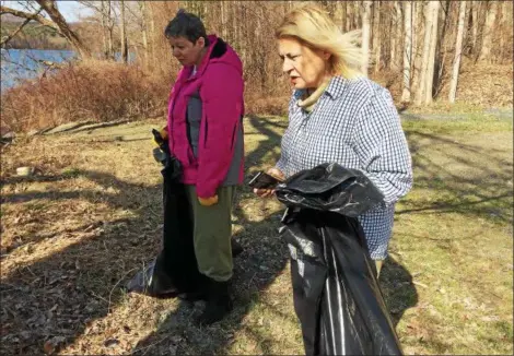  ?? PHOTOS BY GLENN GRIFFITH — GGRIFFITH@DIGITALFIR­STMEDIA.COM ?? Margaret Miele, left, and her sister, Debbie Miele-Wen, helped clean the Tomhannock Reservoir shoreline Saturday.