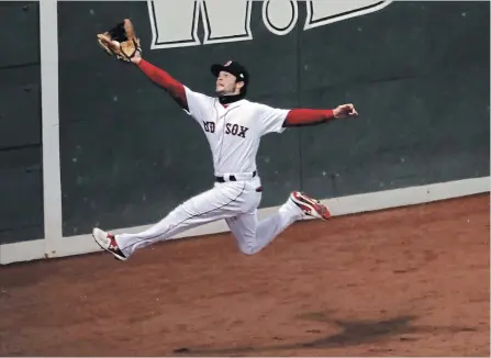  ?? CHANG W. LEE THE NEW YORK TIMES ?? Boston’s Andrew Benintendi leaps to catch a long ball hit by Los Angles Dodgers’ Brian Dozier in Game 2 of the World Series on Wednesday night.