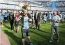  ?? Picture: LEE SMITH/REUTERS ?? DONE AND DUSTED: Manchester City fans celebrate on the pitch after their 1-0 win over Chelsea secured their Premier League win