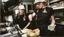  ?? Arnold Gold / Hearst Connecticu­t Media ?? Edd’s Place owner and chef Liz Wood, right, adds parsley to a shrimp tacos order while training Priscilla Dorothy at the restaurant in Westbrook on Thursday.