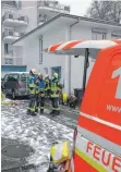  ?? FOTO: FEUERWEHR ?? Einsatzkrä­fte der Feuerwehr beraten sich vor dem Haus über weitere Maßnahmen und halten sich für einen Löschangri­ff bereit.