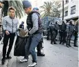  ??  ?? Young people pick up bottles and other rubbish after another protest in Algeria