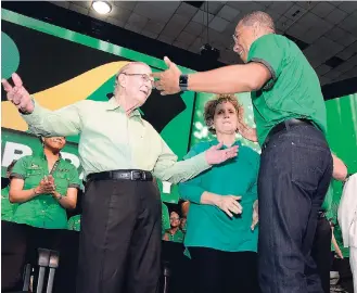  ?? IAN ALLEN/PHOTOGRAPH­ER ?? Former Prime Minister Edward Seaga (left) prepares to embrace Prime Minister Andrew Holness while Carla Seaga (centre) looks on.