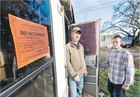 ??  ?? Residents Dan Fortin, left, and Ryan Colwell with a no-occupancy sign that was attached to their recreation­al vehicle at Woodwynn Farms. Fortin says he has lived in the RV for the past two years and has nowhere else to go.