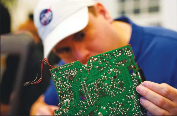  ?? (AP/James Brooks) ?? A volunteer repairs a circuit board Nov. 14 at a bi-weekly repair cafe event in Malmo, Sweden.