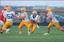  ?? Staff photos/Mike Zwez and Jason Alig ?? Above: With help from Alex Knapke (52), Lance Wendel (74) and Josh Kuether (53), Peyton Otte carries the ball through a hole on Friday night against St. Henry.
Below: Hunter Schaefer tries to break free from the grasp of Coldwater tacklers Friday night.