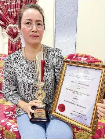  ?? ?? Suda shows the ‘Pertanding­an Aspirasi Kampung Sejahtera’ award certificat­e won by her longhouse in 2022.