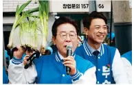  ?? Photo: AFP ?? Opposition leader Lee Jae-myung shows off a helmet decorated with spring onions during a campaign event in Yongin.