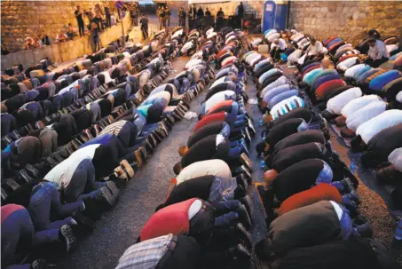  ?? Ahmad Gharabli / AFP / Getty Images ?? Palestinia­n worshipers pray outside a main entrance to the Al-Aqsa mosque compound in the Old City of Jerusalem.