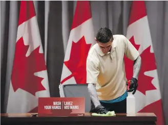  ??  ?? A government maintenanc­e staff member disinfects a desk on Parliament Hill during the COVID-19 pandemic in Ottawa.