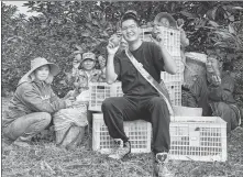  ?? PROVIDED TO CHINA DAILY ?? Dameng (center) posing for a photo with local farmers.