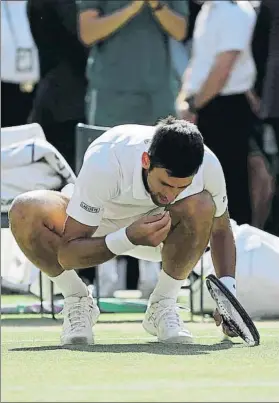  ?? FOTO: AP ?? Djokovic, comiendo hierba de la central. Su propia tradición cuando es campeón